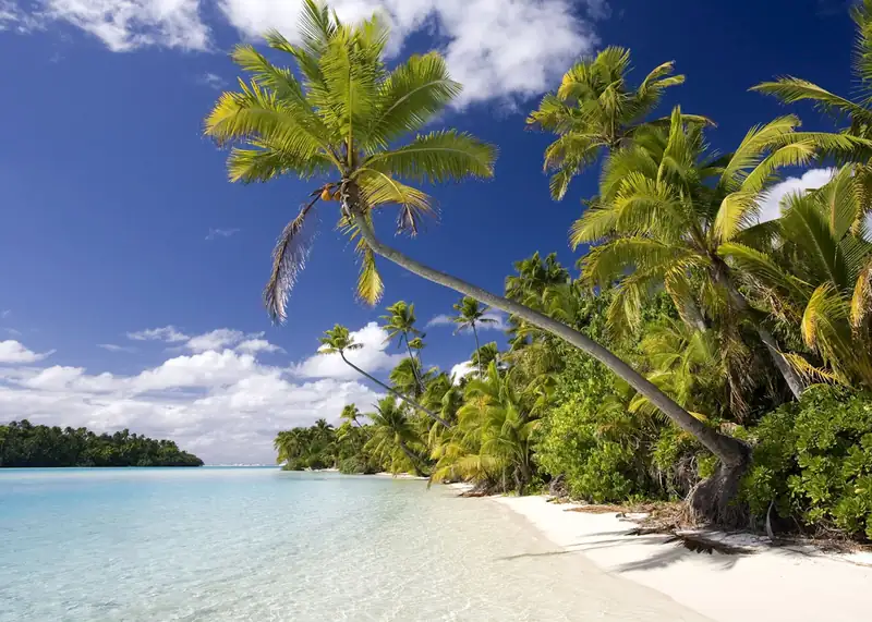 Beautiful lagoon in the Cook Islands with vibrant coral reefs and lush green islands surrounding the clear waters